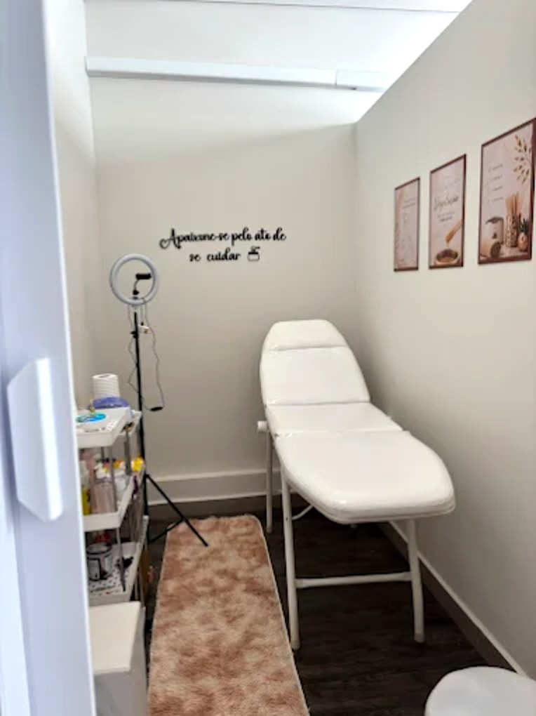 Sala de atendimento da Bem de Pele: maca preparada, ring light e carrinho de materiais